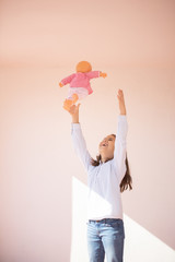 Niña de pie jugando con una muñeca en la azotea