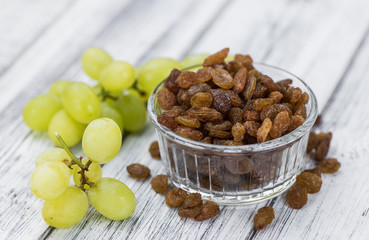 Portion of healthy Raisins on an old wooden table (selective focus; close-up shot)