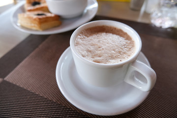 Coffee in a white cup and saucer. The hotel is all-inclusive. Morning breakfast.