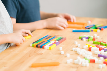 Little asian boys learn about numeracy, adding - subtracting and counting through colorful cuisenaire rods. Early math, Cognitive skills, Learning tools, Child development, Educational concept.