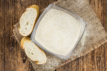 Some fresh Bread Crumbs on wooden background (selective focus; close-up shot)
