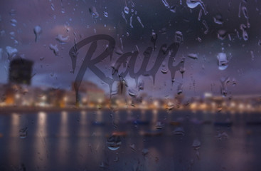 Obraz na płótnie Canvas word rain written on foggy window in rainy weather outdoors