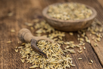 Portion of healthy Oat on an old wooden table (selective focus; close-up shot)