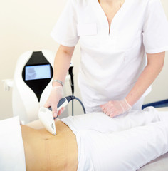Obraz premium Woman gets laser and ultrasound treatment of face and body at medical spa, skin rejuvenation concept
