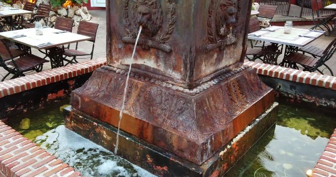 An old fountain spiting water in slowmotion.