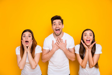 Portrait of funny three people shouting yelling wearing white t-shirt isolated over yellow background