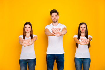 Portrait of strict mates crossing palms wearing white t-shirt denim jeans isolated over yellow background