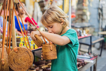 Boy at a market in Ubud, Bali. Typical souvenir shop selling souvenirs and handicrafts of Bali at the famous Ubud Market, Indonesia. Balinese market. Souvenirs of wood and crafts of local residents