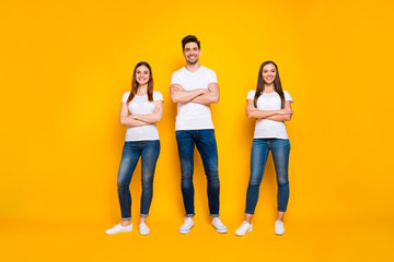 Obraz premium Full size photo of positive buddies with toothy smile crossing hands wearing white t-shirt isolated over yellow background