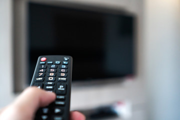 hand holding remote control point to television