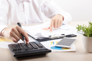 Close up of female accountant or banker making calculations. Savings, finances and economy concept