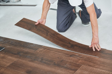 worker joining vinyl floor covering at home renovation - 291664583