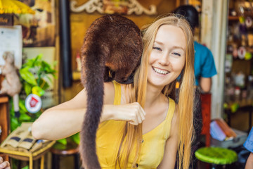 Young woman with musang coffee kopi luwak producer. Bali island