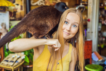 Young woman with musang coffee kopi luwak producer. Bali island