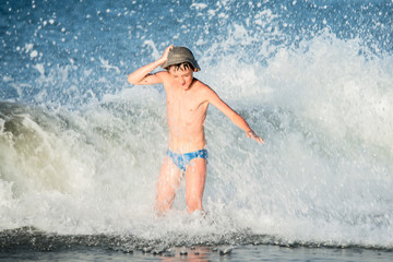 Boy in the spray of waves.