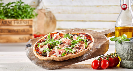 Thin crust Italian pizza with prosciutto ham