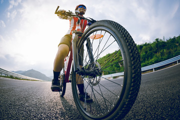 Obraz na płótnie Canvas Woman cyclist riding bike on highway