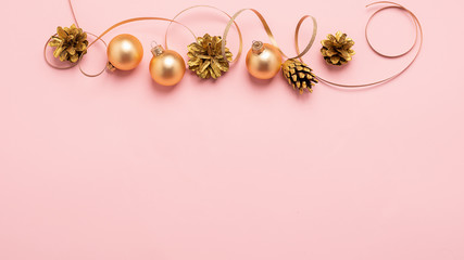 New Year or Christmas layout balls serpentine cones of gold color on a pink background. Holiday concept. Flat layout.