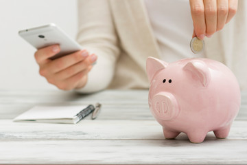 woman hand putting money coin into piggy for saving money wealth and financial concept