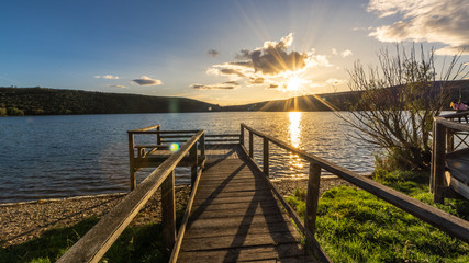 Views during the beautiful sunset on the dock for fishing of the Selga de Ordas reservoir in Leon, Spain