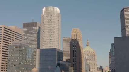 A medium shot with an upward tilting view of the backside of The Empire State Building with its window glass facade and spire located in New York City, NY, United States. - Powered by Adobe