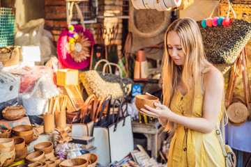 Woman traveler choose souvenirs in the market at Ubud in Bali, Indonesia