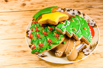 Plate with different christmas gingerbread cookies on wooden table