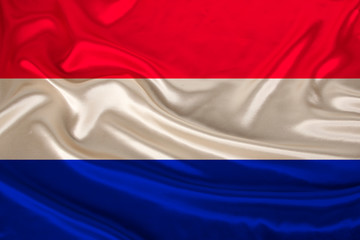 national flag of the country Holland on gentle silk with wind folds, travel concept, immigration, politics, copy space, close-up
