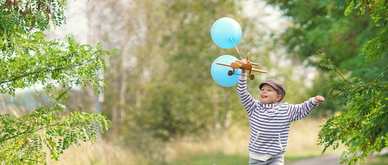 kleiner Junge spielt mit Holzflieger