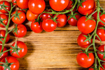 Heap of small cherry tomatoes on wooden table. Top view