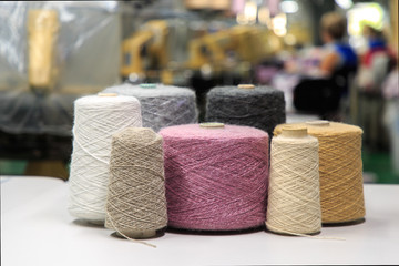 Multicolored bobbins of wool yarn for hand and machine knitting. Selective focus. - Powered by Adobe