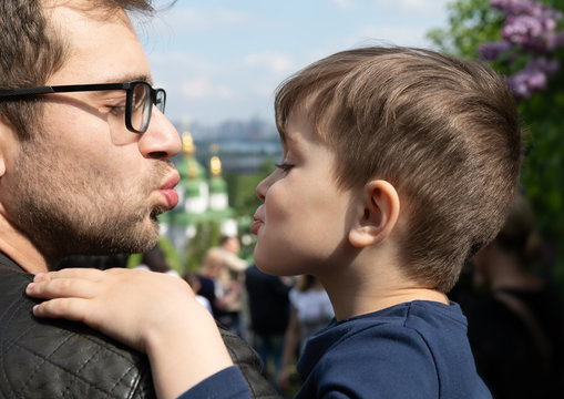 ather kisses his little son