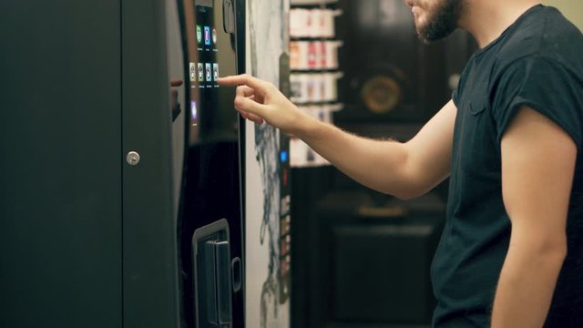Young Man Buying Coffee Vending Machine