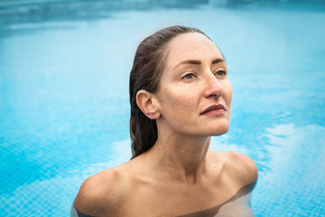 Beautiful woman swimming naked in a swimming pool