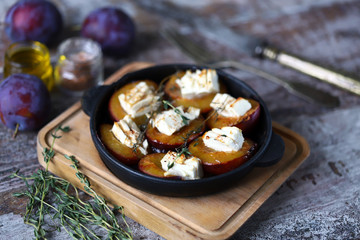 Baked plums with feta cheese. Healthy lunch or snack. Vegetarian food. Selective focus. Macro.