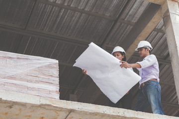 Consultant engineer discussing construction project in blueprint; Consulting concept in construction at office indoor