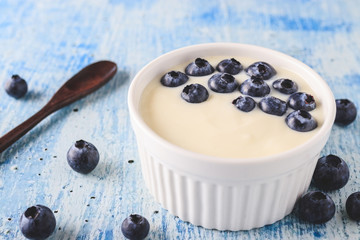 Yogurt with fresh blueberries on wooden background. Health concept.
