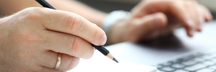 Male hand writing something with regular lead pencil