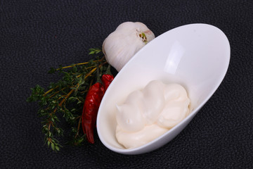 Mayonnaise sauce in the white bowl served thyme and garlic