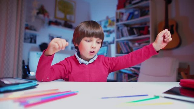 the child sits at a table, takes a pencil and begins to draw