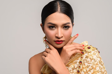 Women wearing Thai clothes and hands touching their faces