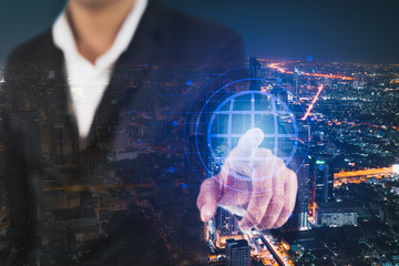 The double exposure image of businessman touching a modern virtual interface icon technology with cityscape. Online business and technology concept.
