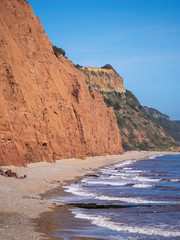 The famous Jurassic Coast red cliffs at Sidmouth, Devon, England. Looking East from Sidmouth Beach to Salcombe Hill Cliff. Vertical shot.
