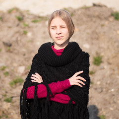 teen girl with blond hair in a hood in the desert
