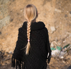 teen girl with blond hair in a hood in the desert