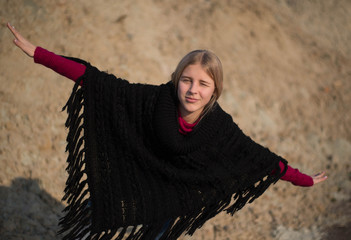 teen girl with blond hair in a hood in the desert