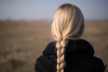 teen girl with blond hair in a hood in the desert