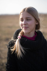teen girl with blond hair in a hood in the desert