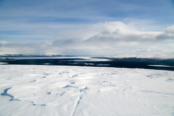 winter landscape with frozen lake and blue sky