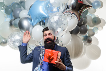 Happy birthday guy holds helium balloons and gift box. Festive event or birthday party. Handsome man celebrating something. Bearded man in suit holds birthday gift. People, joy, birthday, celebration.